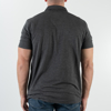 The black polo shirt, viewed from the back. A man is wearing it.