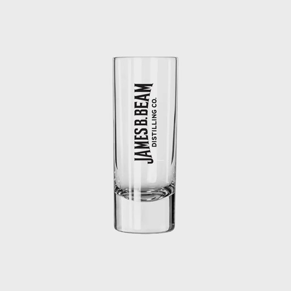 A transparent shot glass, with “James B. Beam Distilling Co.” written in black.