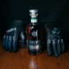 Bottle of Baker's Whiskey between Jim Beam leather biker gloves with Baker's, 107 Proof, $1 and Baker Beam painted on
